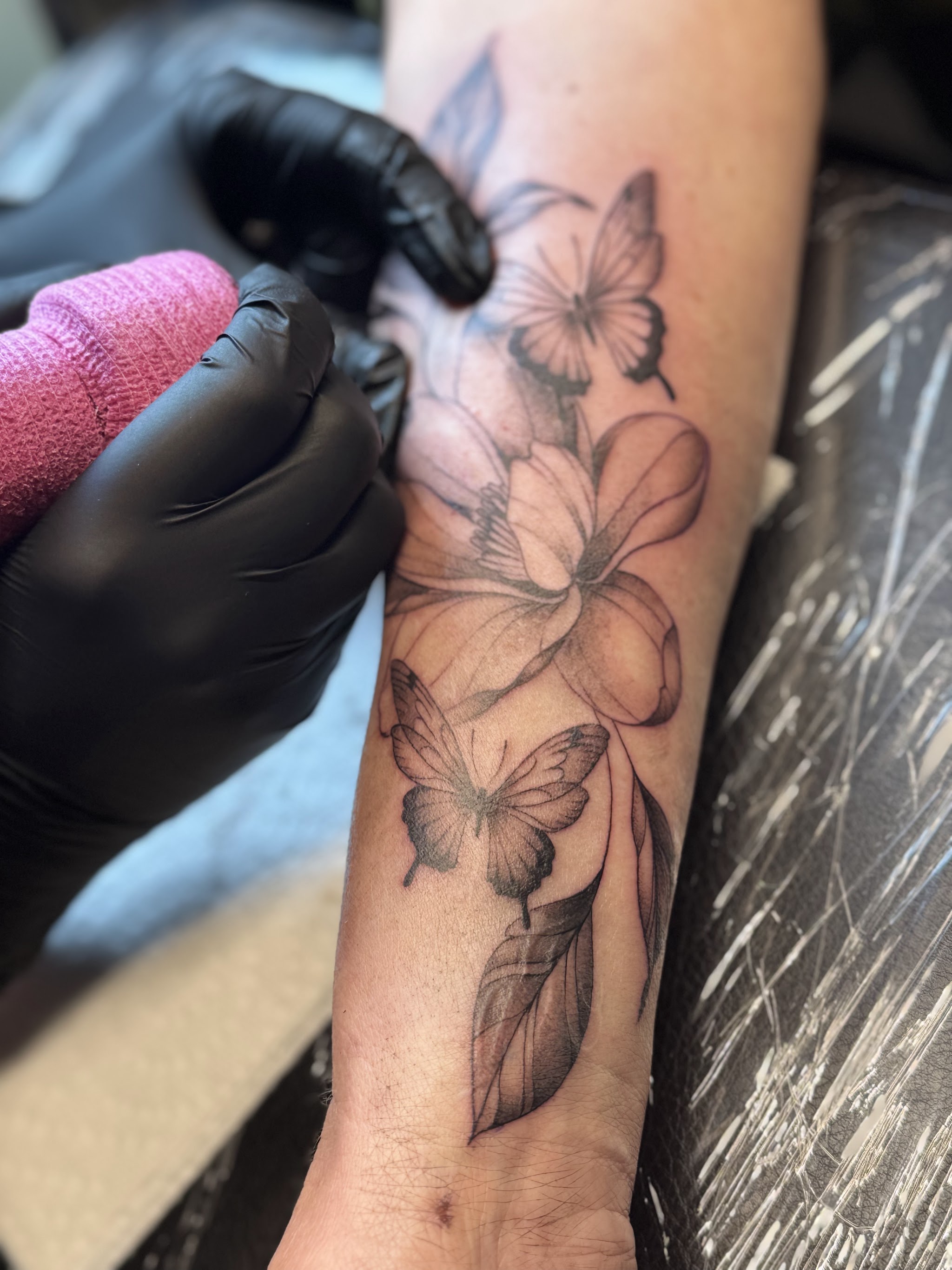 Bloemen en vlinders op een onderarm, tijdens het zetten